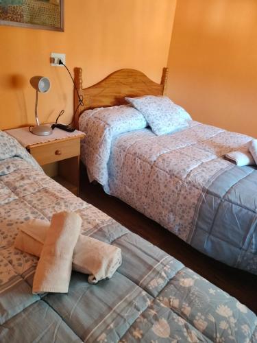 two beds in a hotel room with towels on the beds at Loja centro. in Loja