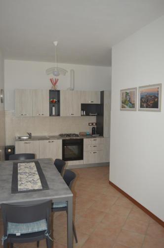 a kitchen with a table and chairs in a room at Casa al Passaggio in Bettona