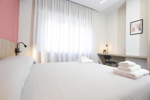 a white bedroom with a large white bed and a window at RIDA 33 Vomero in Naples