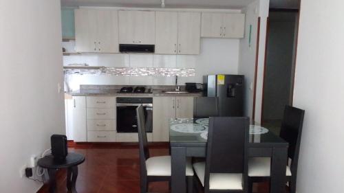 uma cozinha com uma mesa e cadeiras e um frigorífico em Apartamento acogedor en Ibagué em Mirolindo