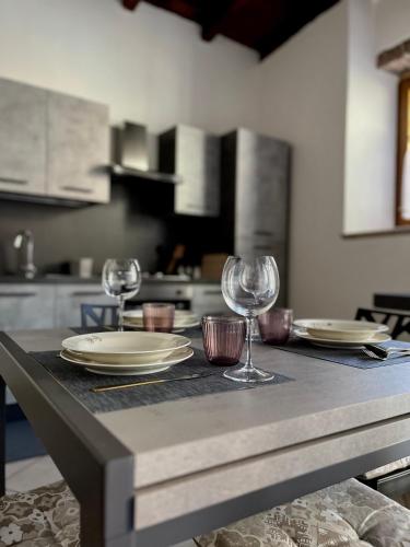 a table with plates and wine glasses on it at Il Casalino, casa centro storico in Montefiascone