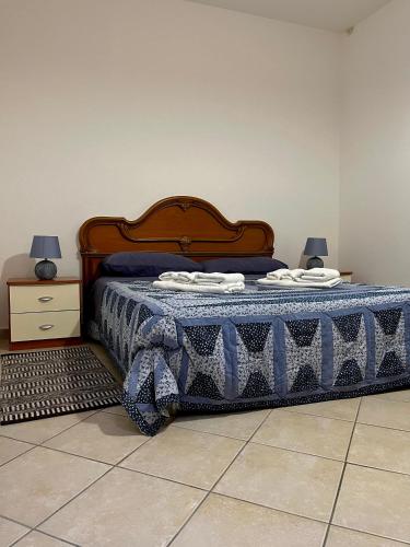 a bedroom with a bed with a blue and white blanket at Il Casalino, casa centro storico in Montefiascone