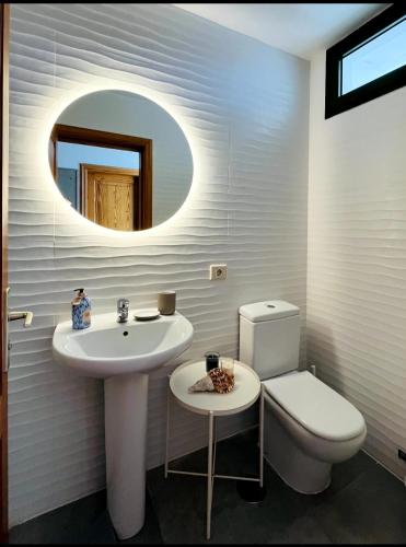 a bathroom with a sink and a toilet and a mirror at Céntrico y tranquilo in Costa Teguise