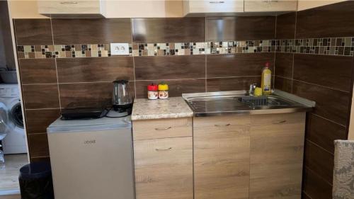 una pequeña cocina con fregadero y nevera. en Apartments M&T, en Tivat