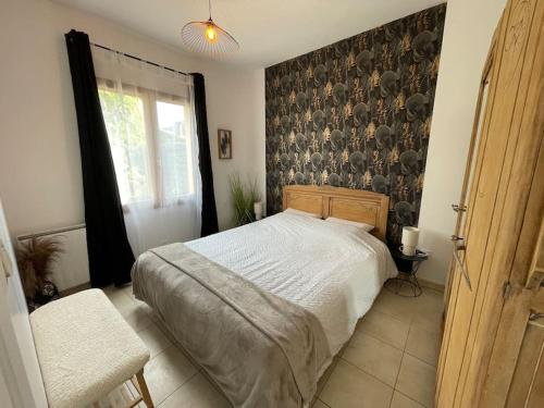 une chambre avec un lit et un mur dans l'établissement Les jardins de Gabriel, à Bergerac