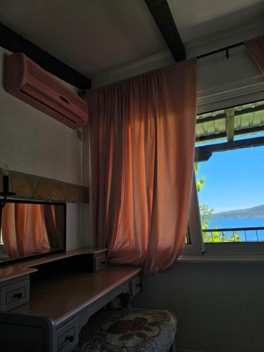 a room with a mirror and a desk and a window at Apartmani VERONA in Bijela