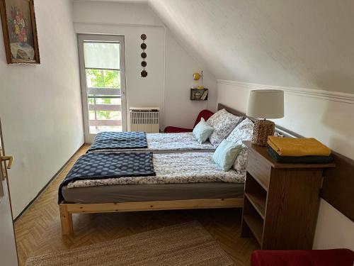 um quarto com uma cama e uma janela em Hilóczki Vendégház em Bogács