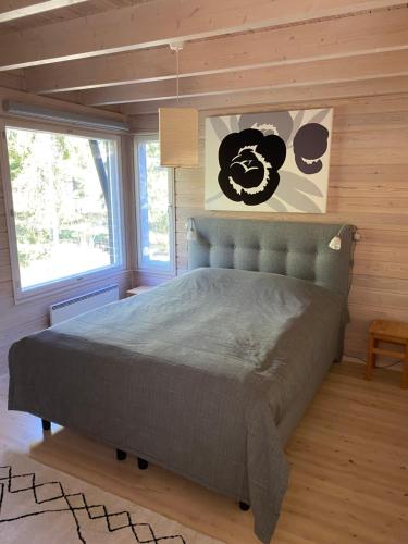 - une chambre avec un lit dans une pièce dotée de murs en bois dans l'établissement Pirttiranta, à Iitiä