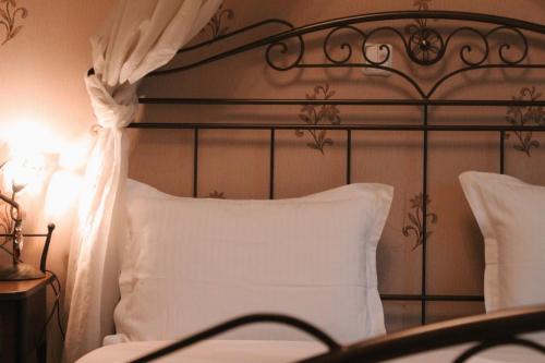 a bed with a black headboard and a white pillow at Enastron Hotel in Kato Loutraki