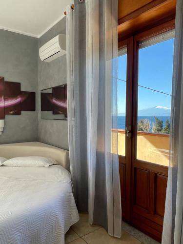 um quarto com uma cama e vista para o oceano em B&B Villa Magna Grecia em Lazzaro