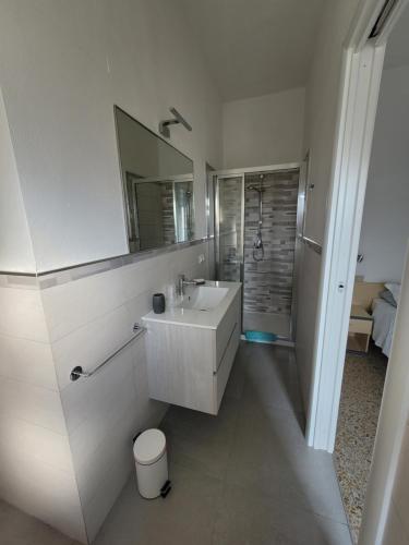 a white bathroom with a sink and a mirror at Affittacamere La Zattera in Lido di Camaiore