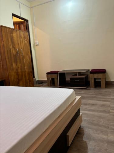 a bedroom with a bed and a desk and a table at BLUE DUKE HOMESTAY in Ravangla