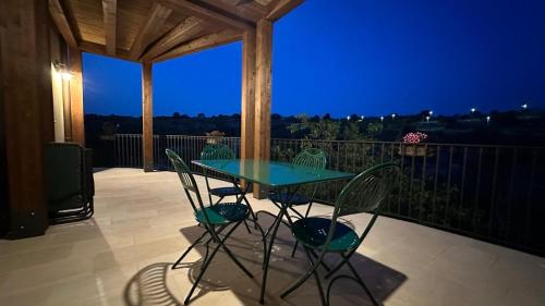 a table and chairs on a balcony at night at Casa vacanze Il Mandarancio in Modica
