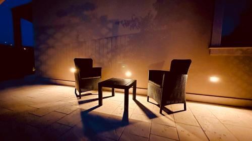 two chairs and a table in a dark room at Casa vacanze Il Mandarancio in Modica