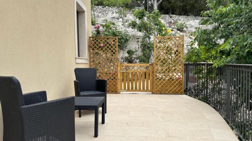 a patio with chairs and a gate with flowers at Casa vacanze Il Mandarancio in Modica