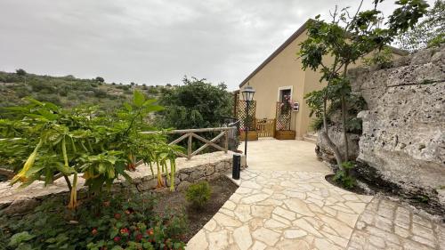 a house with a stone wall and a walkway at Casa vacanze Il Mandarancio in Modica