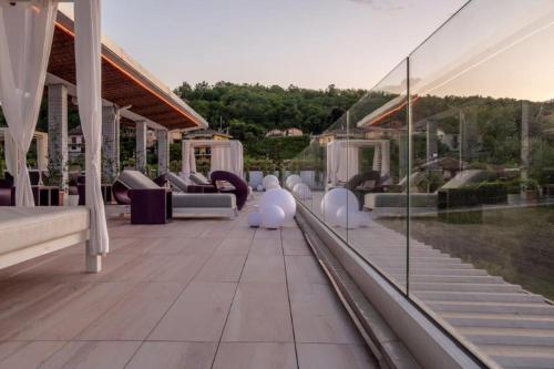 an outdoor patio with white furniture and glass walls at Hotel Le Palme in Dormelletto