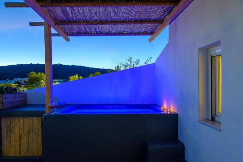 a hot tub on the side of a house at Athiri Luxury Suites in Perivolos