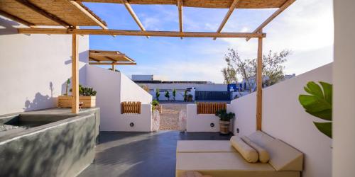a patio with white walls and a wooden roof at Athiri Luxury Suites in Perivolos