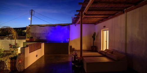 a house with a purple light on the side of it at Athiri Luxury Suites in Perivolos