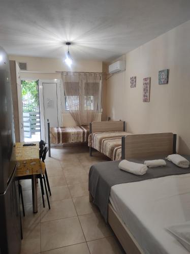 ein Hotelzimmer mit 2 Betten, einem Tisch und einem sidx sidx in der Unterkunft Nikos house studios in Ofrynio