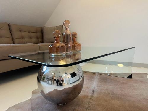 a glass table with bottles on top of it in a living room at Stuttgart Lux Living - Stilvolles Wohnen Im Zentrum in Stuttgart