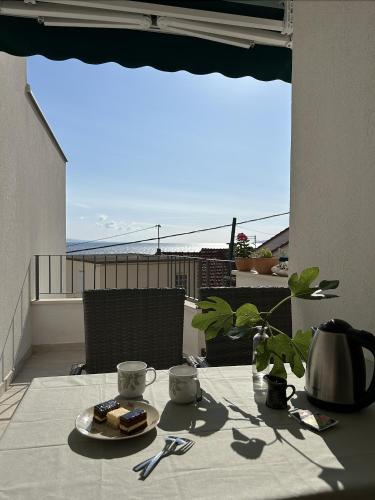 a table with a plate of food on a balcony at Beach House Buinac in Brist