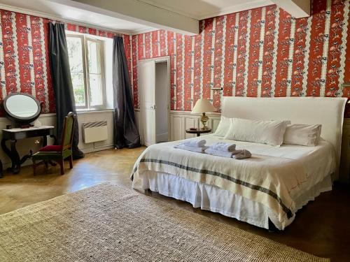 a bedroom with a large bed with red wallpaper at La Suite de la Bastide in Val-de-Dagne