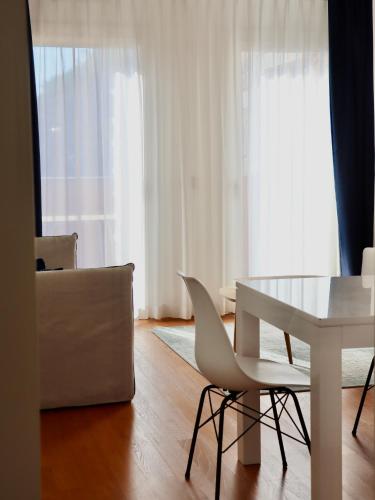 a living room with a white table and chairs at Portopiccolo Apartments in Sistiana