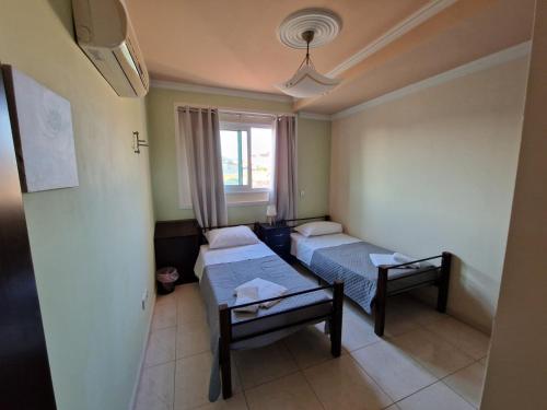 a small room with two beds and a window at Family House in Paphos City