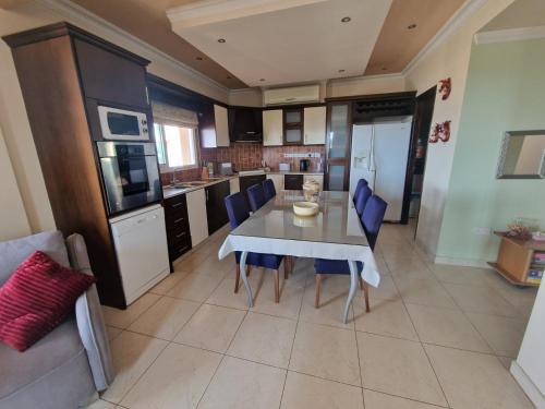 a kitchen with a table and blue chairs in a room at Family House in Paphos