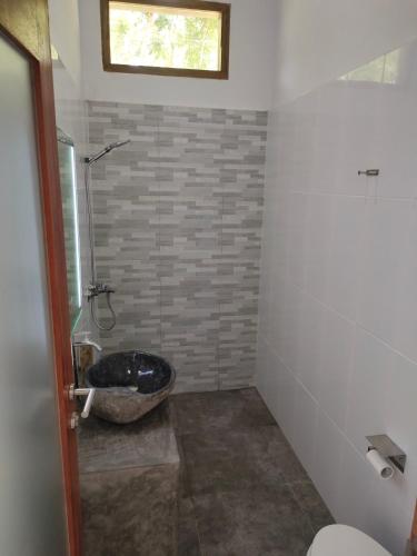 a bathroom with a toilet and a sink at Vera Koe in Kuta Lombok