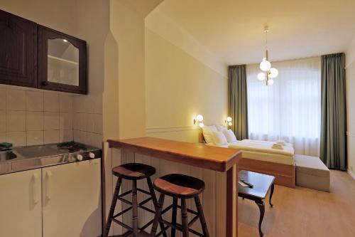 a hotel room with a kitchen and a bed at Hotel Kavalír in Karlovy Vary