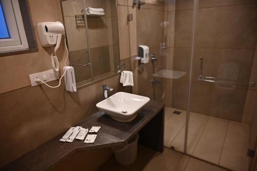 a bathroom with a sink and a shower at Soho Boutique Hotel in Mysore