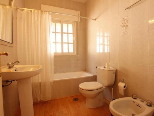 a white bathroom with a toilet and a sink at Villa Alegría in Roche
