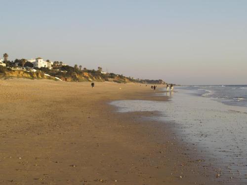 a group of people walking on the beach at Villa Alegría in Roche