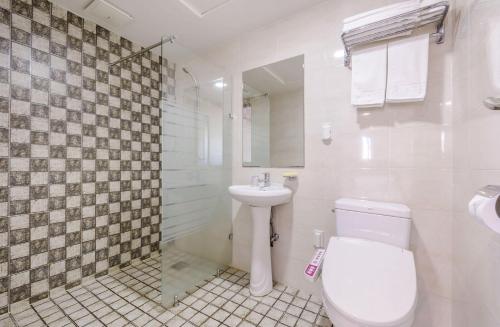 a white bathroom with a toilet and a sink at Pine Hill Hotel in Seogwipo