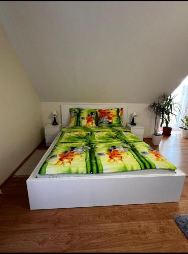 a bedroom with a bed with a green comforter at Zielony Gaj in Gaj