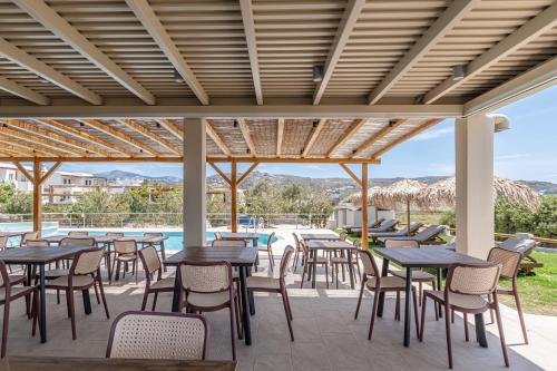 a patio with tables and chairs and a pool at Golden Sand in Plaka