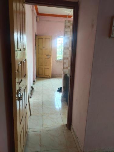 pusty korytarz z dwoma drzwiami i podłogą wyłożoną kafelkami w obiekcie Radhesham bhakt niwas w mieście Pandharpur