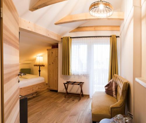 um quarto com uma cama, um sofá e uma janela em Gästehaus Reicher em Afritz