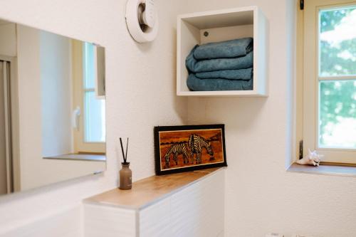 a bathroom with a mirror and a shelf with towels at Villa Levin - 56qm, bis 4 Personen, free Wifi & parken 