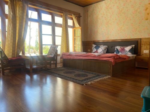 a bedroom with a bed and a large window at Jimmys homestay in Leh