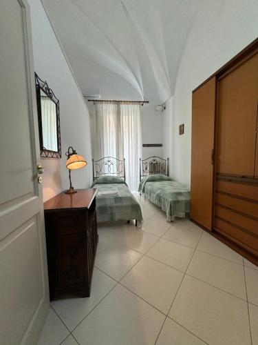 a bedroom with two beds and a table with a lamp at Palazzo Quey in Lecce