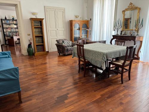 a dining room with a table and chairs in a room at Palazzo Quey in Lecce