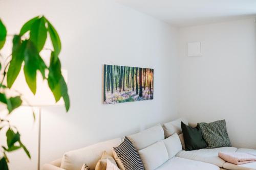 a living room with a white couch and a painting on the wall at Villa Levin - 56qm, bis 4 Personen, free Wifi & parken in Steudnitz