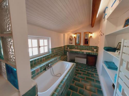une grande salle de bain avec une baignoire et un lavabo dans l'établissement Bastide Provencale dans les vignes, au Castellet