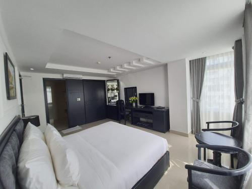 1 dormitorio con 1 cama blanca grande y escritorio en Kay Hotel Da Nang, en Da Nang