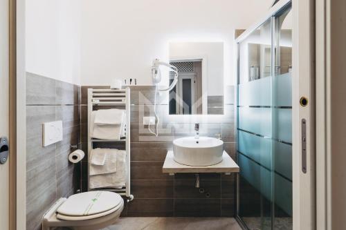un baño con lavabo e inodoro en Gold Apartment, en Ferrara