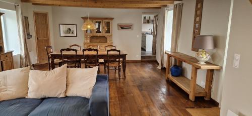 a living room with a couch and a dining room table at Maison à la campagne. in Audembert